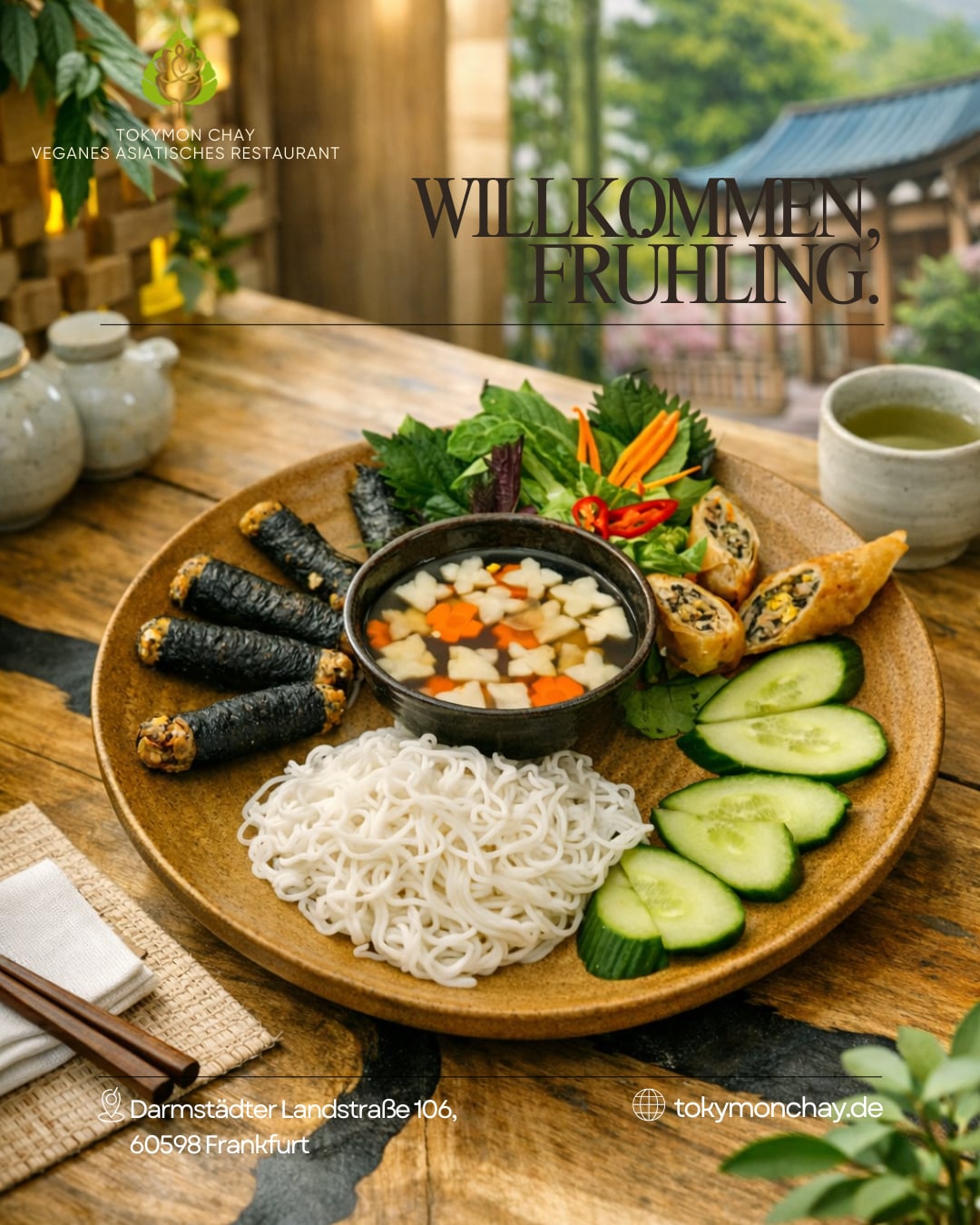 Veganer asiatischer Teller mit Reisnudeln, Rollen, frischem Gemüse und Dip neben einer Tasse Tee